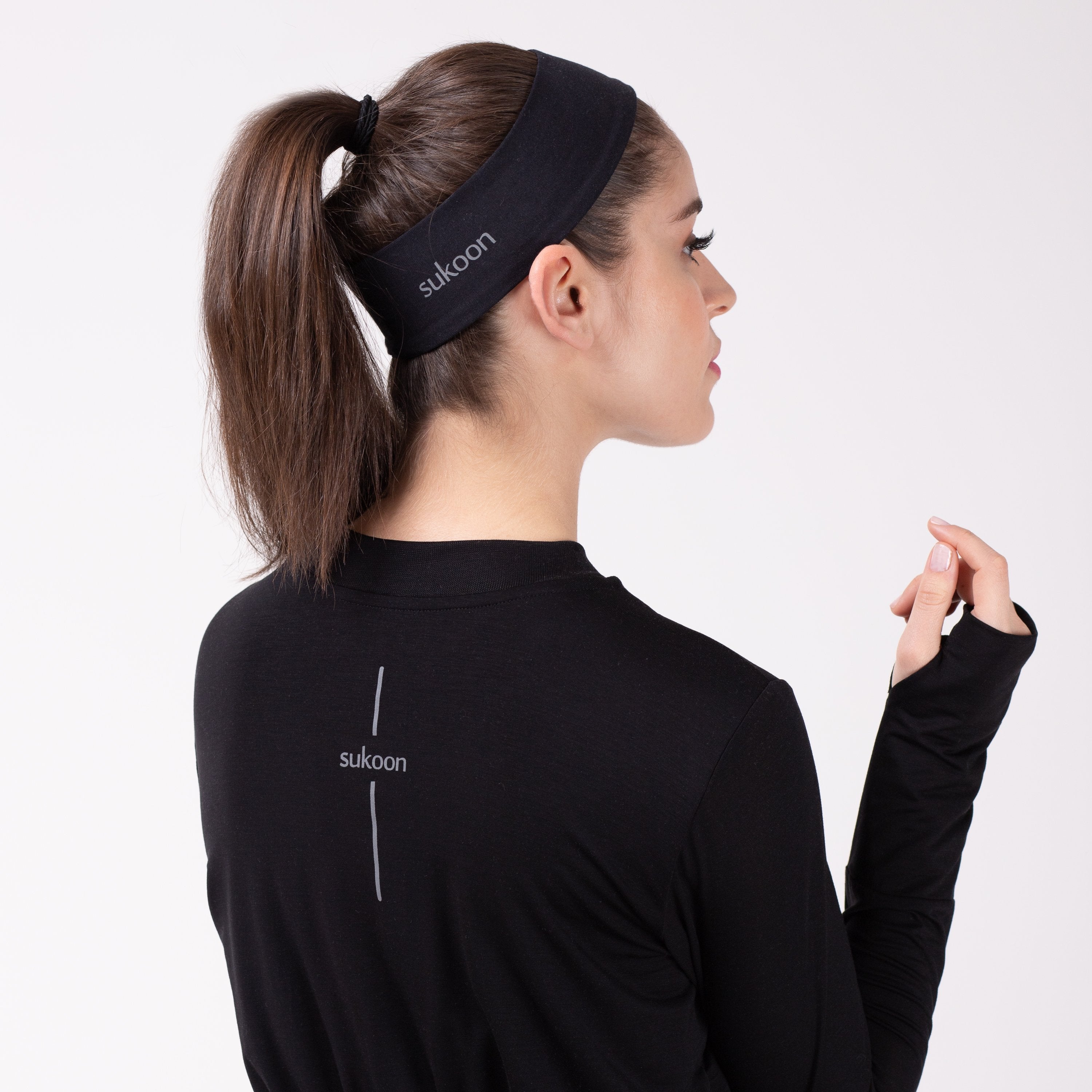 Back detail of woman in black shirt with matching HAWA headband.