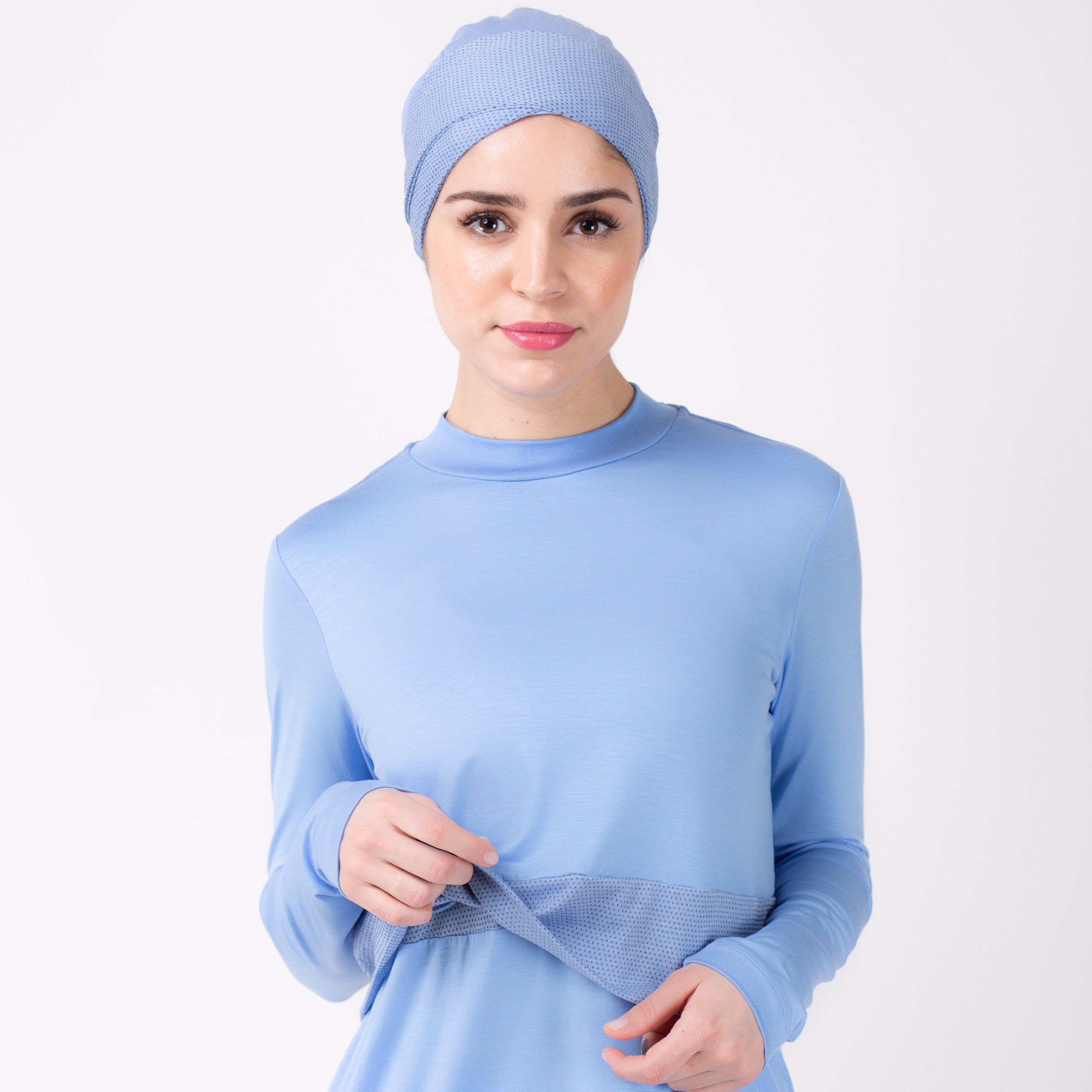 Front detail of woman playing with tiered fabric of sky blue HAWA step tee.