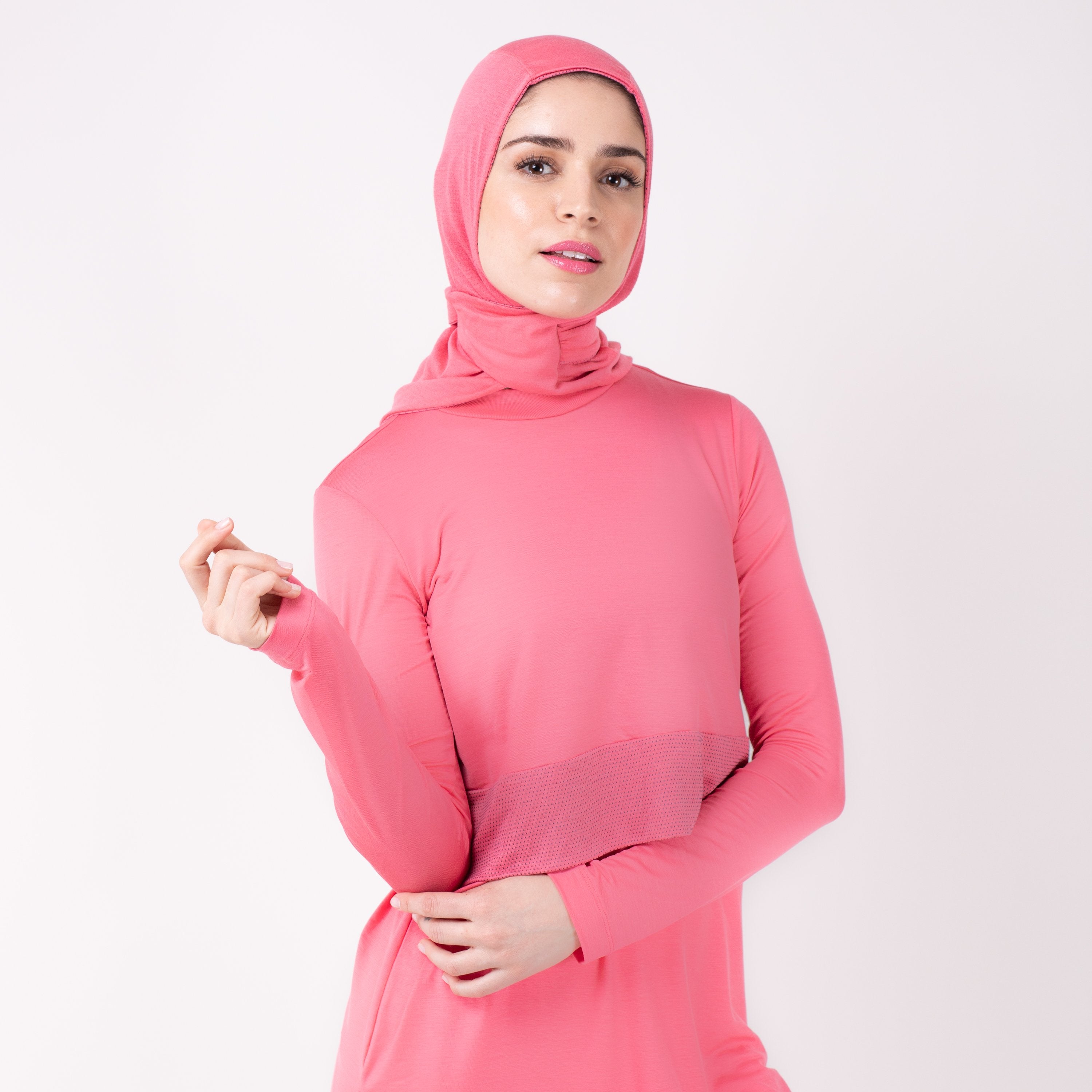 Woman wearing a pink shirt with a matching pink HAWA hijab.