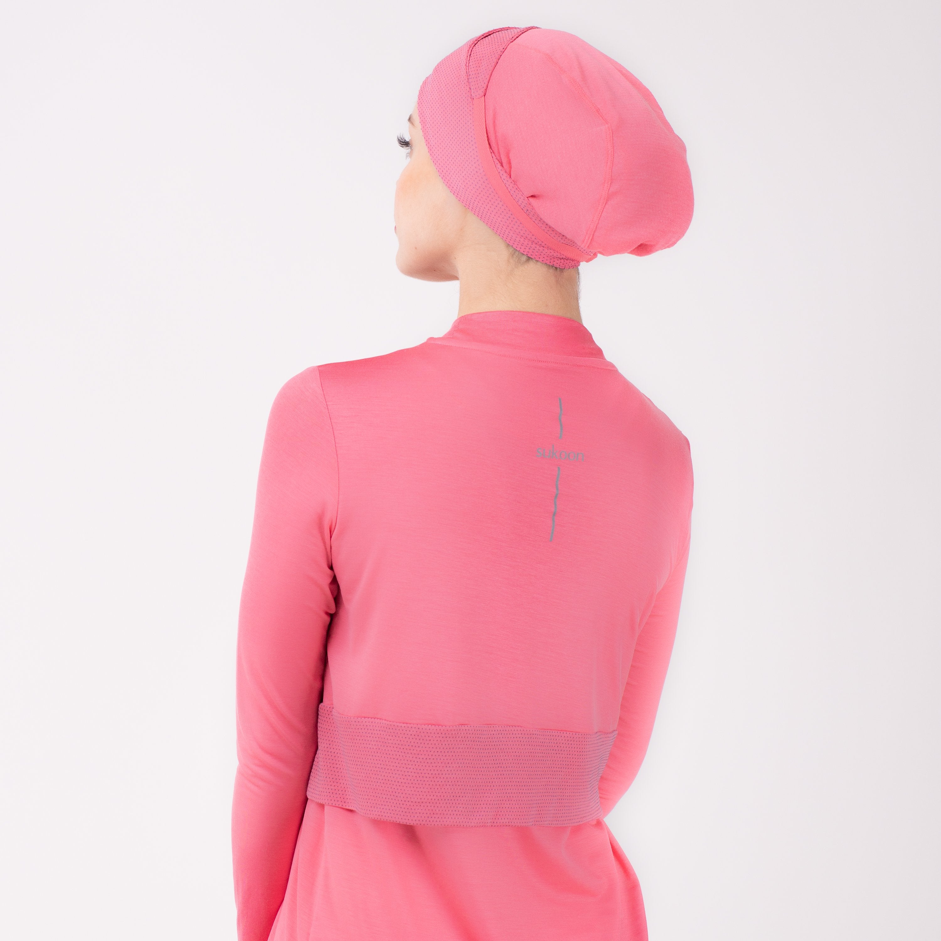 Back detail of woman in pink shirt with matching pink HAWA headwrap.