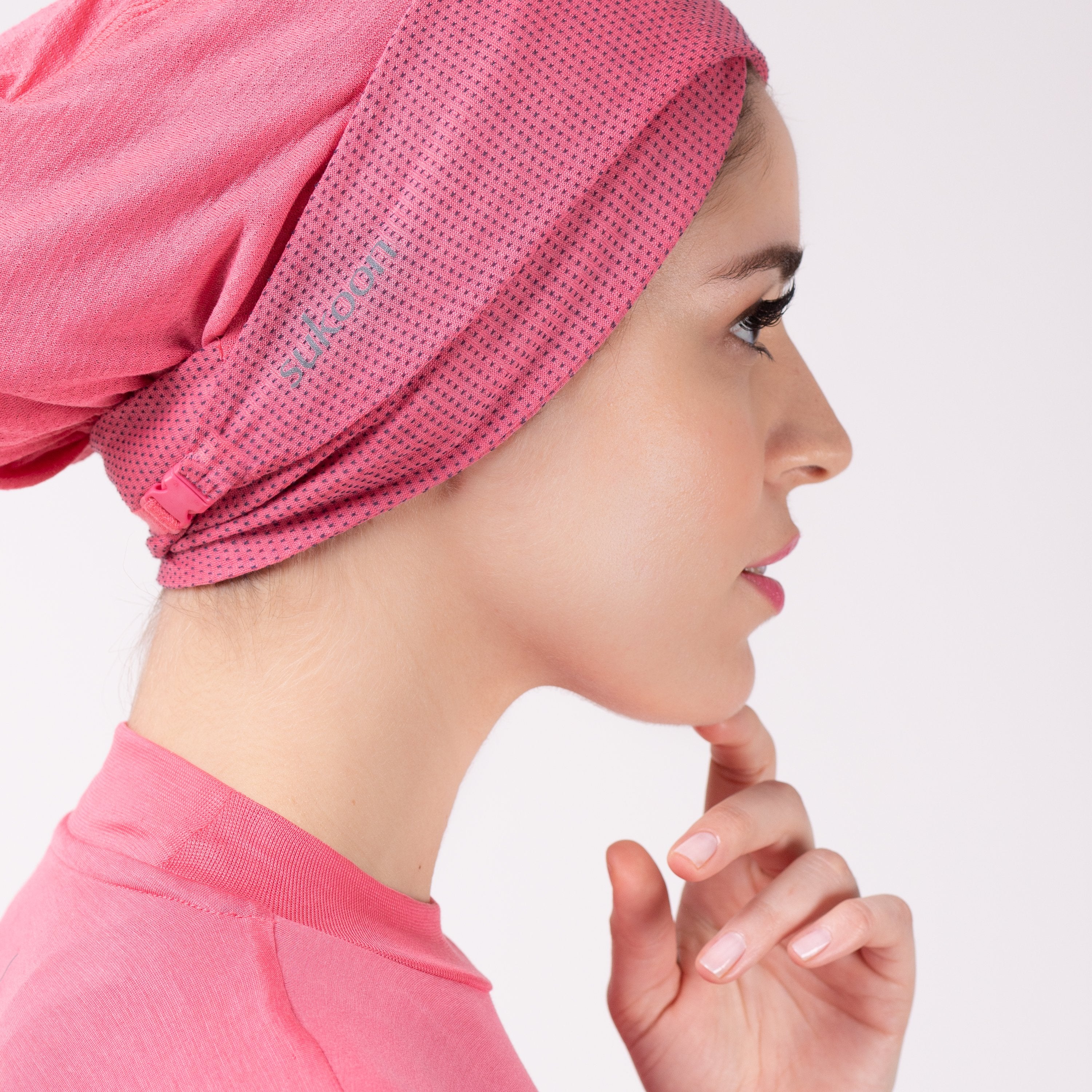 Side detail of woman in pink HAWA headwrap.