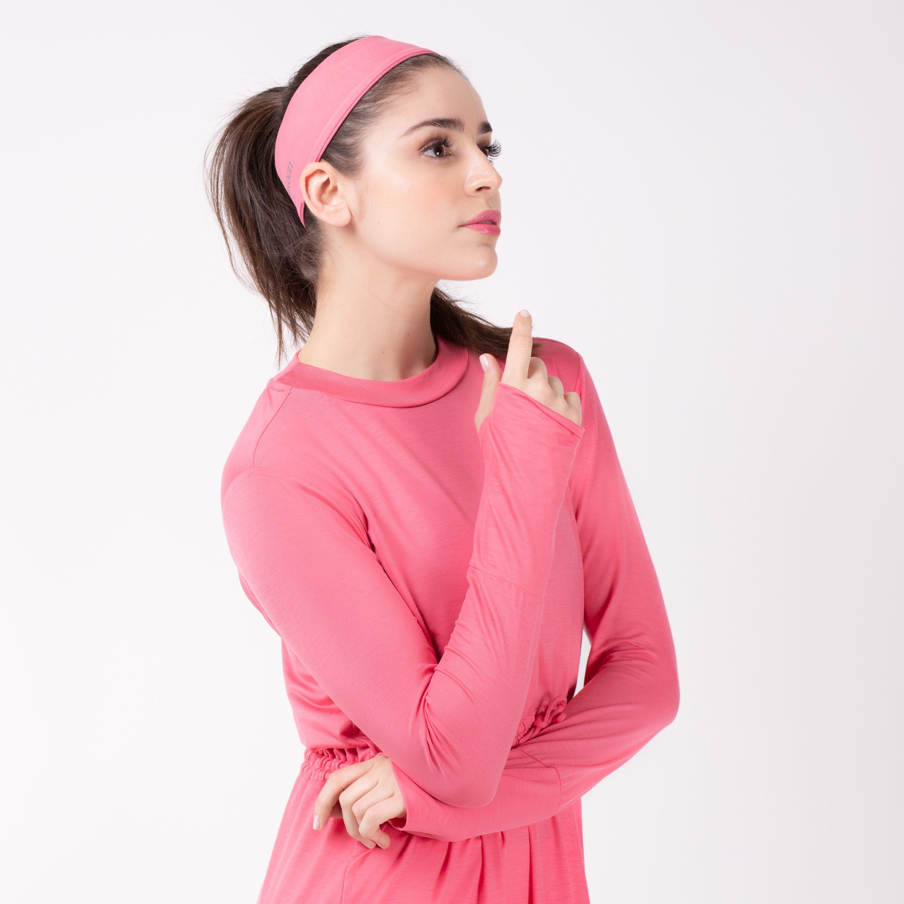 Woman looking right in pink shirt with matching pink HAWA headband.