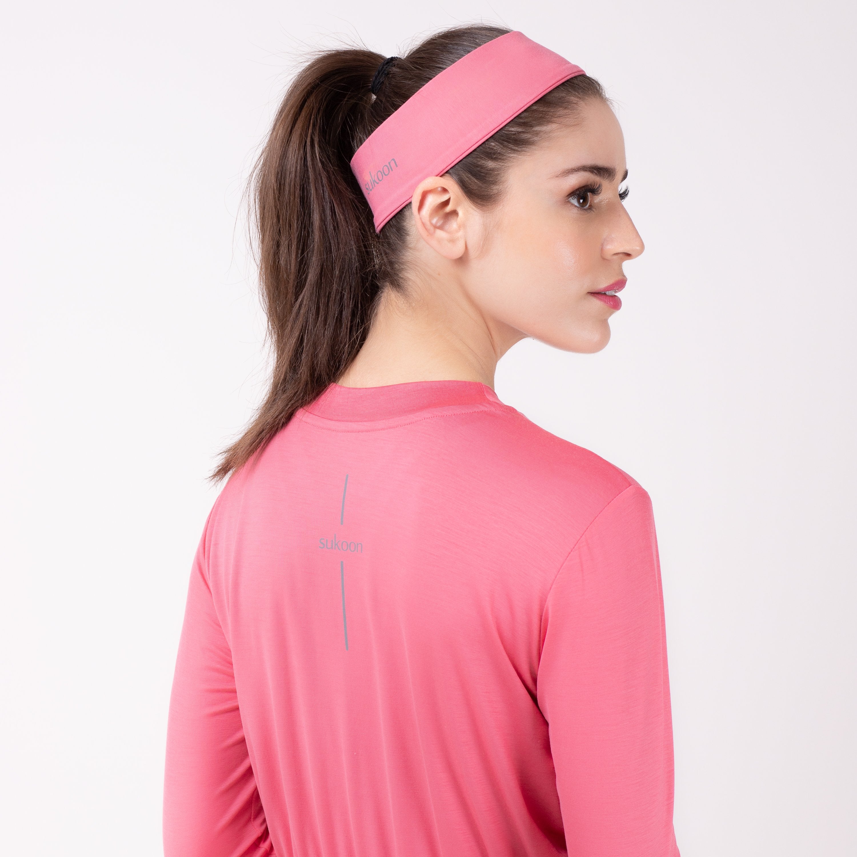 Back detail of woman in pink shirt with matching pink HAWA headband.