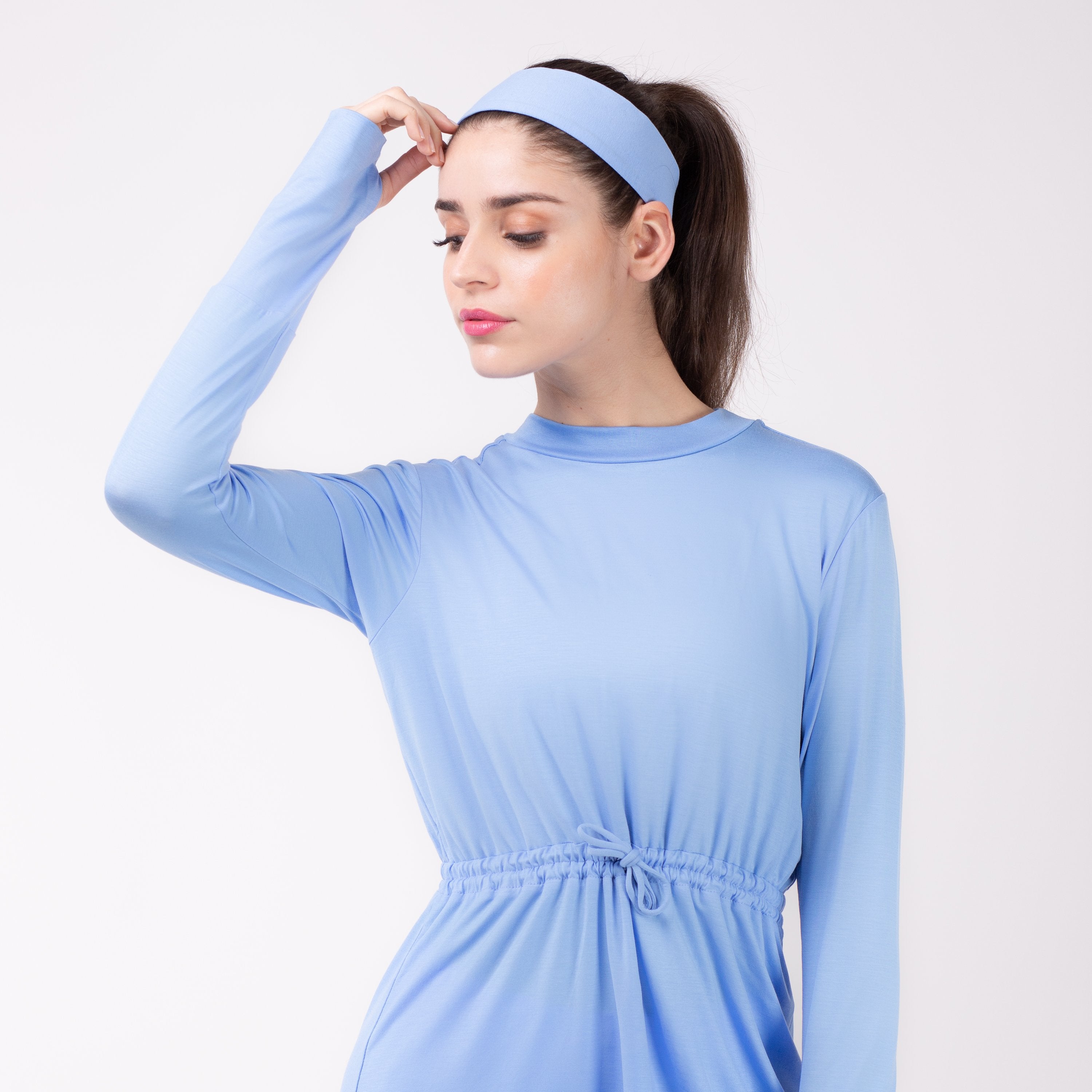 Woman looking left in sky blue shirt with matching sky blue HAWA headband.